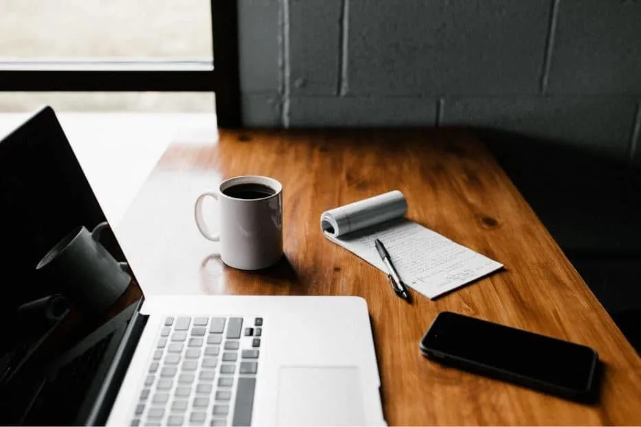 laptop and coffee mug on wooden table