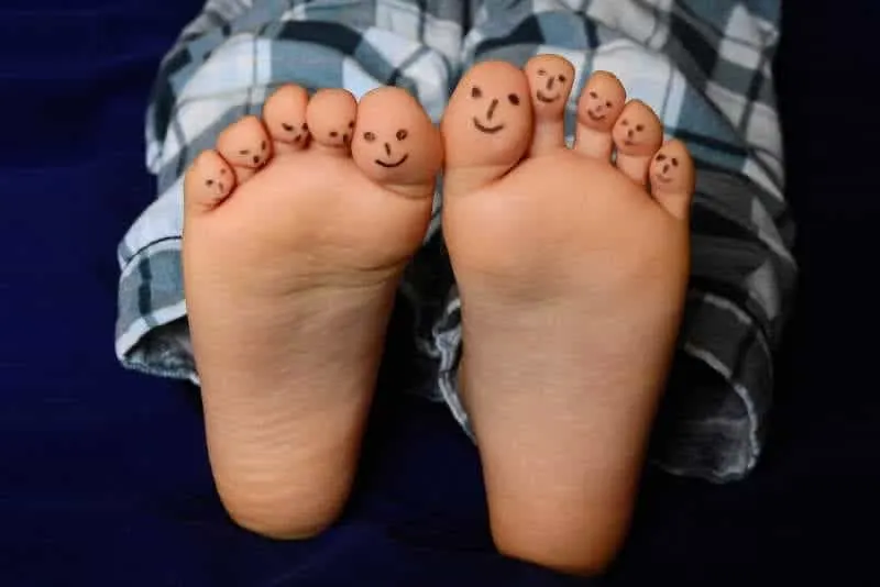 Boy feet with face drawing on toes