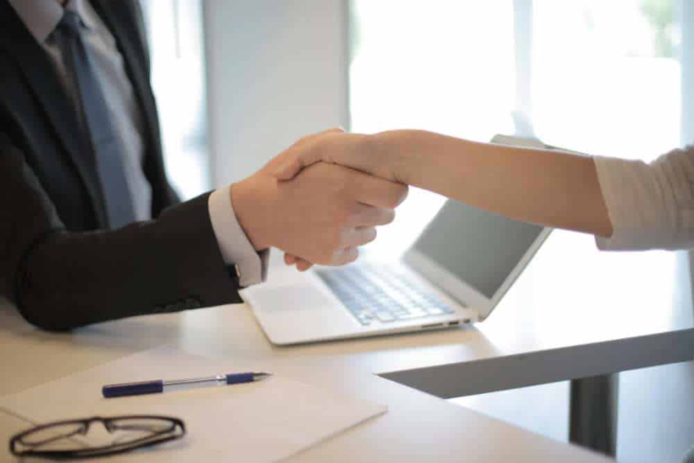 Man and woman shaking hands over a desk