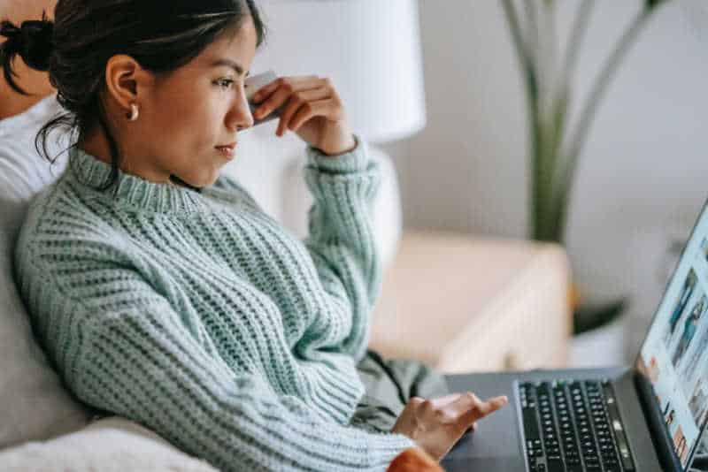 Woman sitting in a sofa working on her laptop