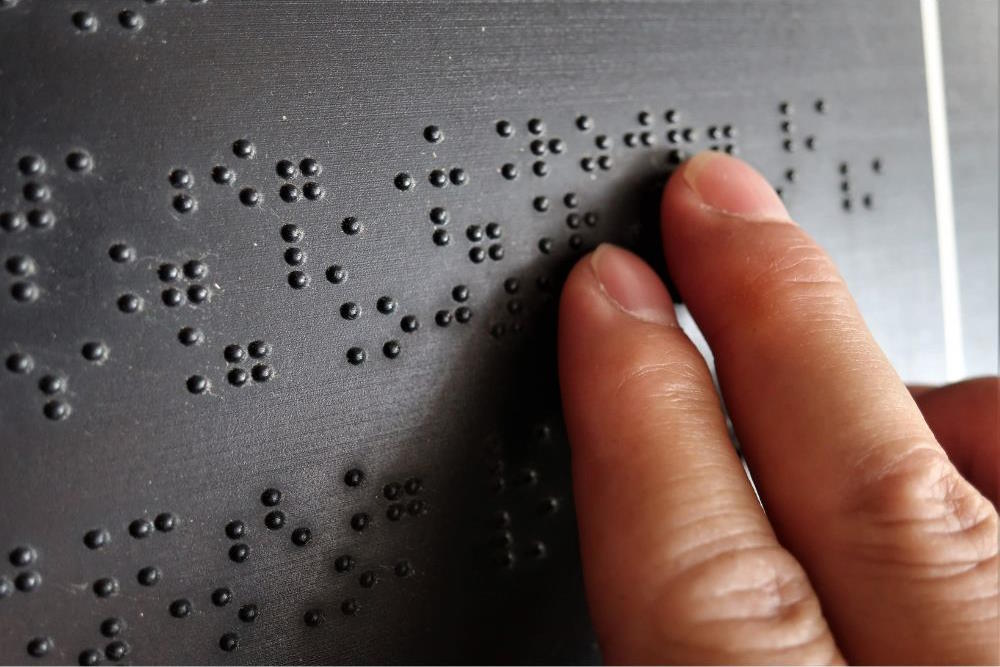 Image via Canva - braille reading