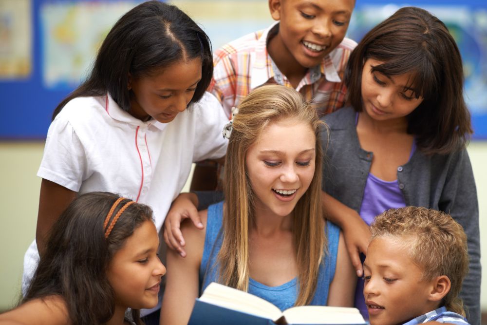 Image via Canvas - foreign teacher reading surrounded by children